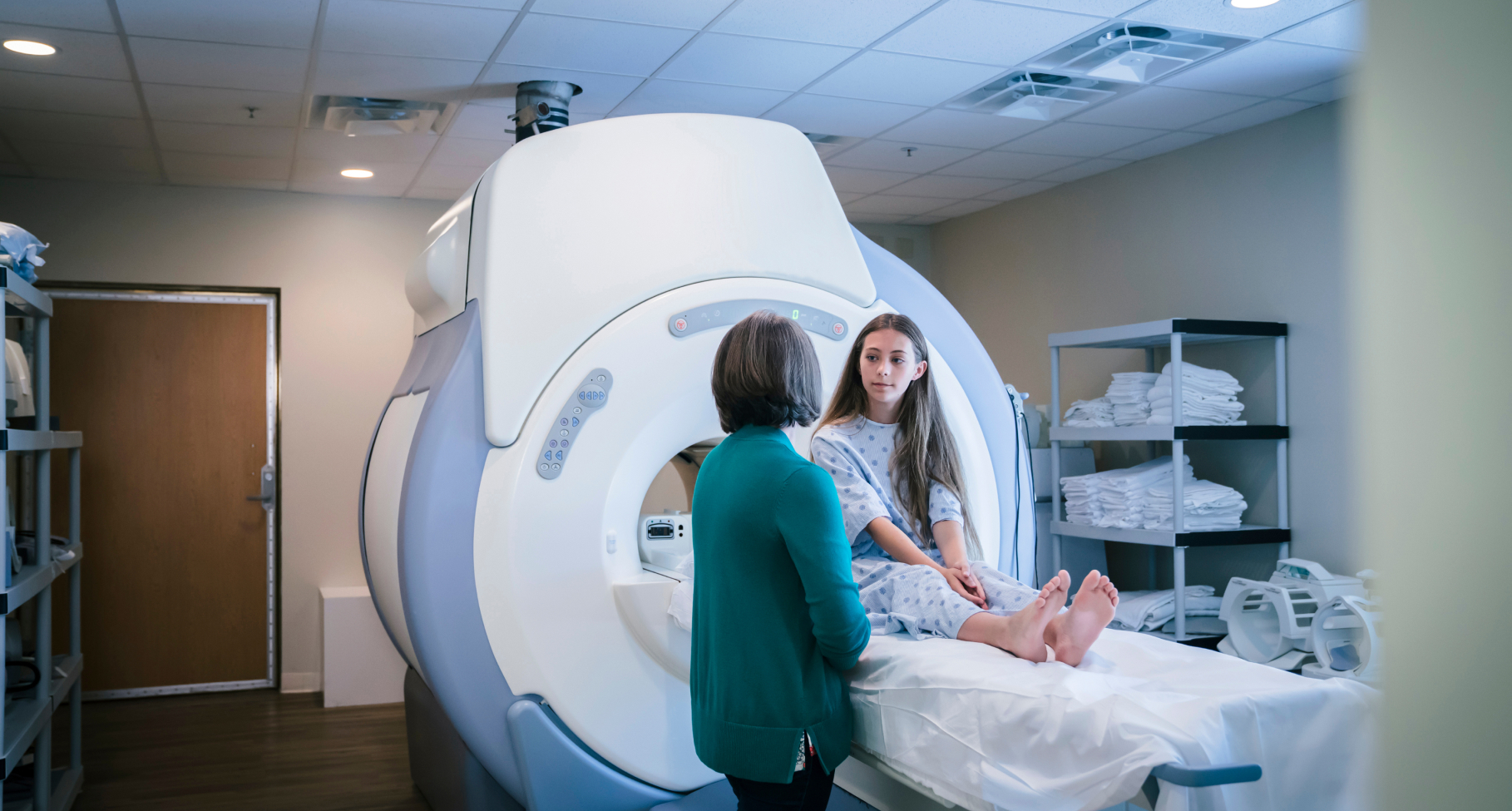 A doctor speaks to a patient waiting in an MRI machine.